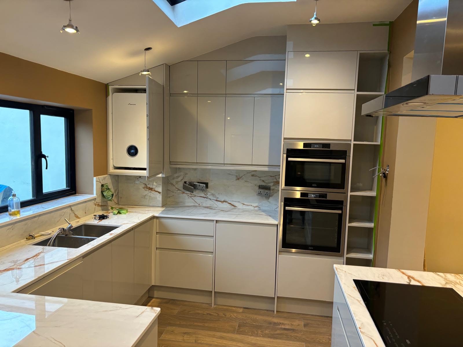 Modern white kitchen with marble worktops, skylight and AEG appliances