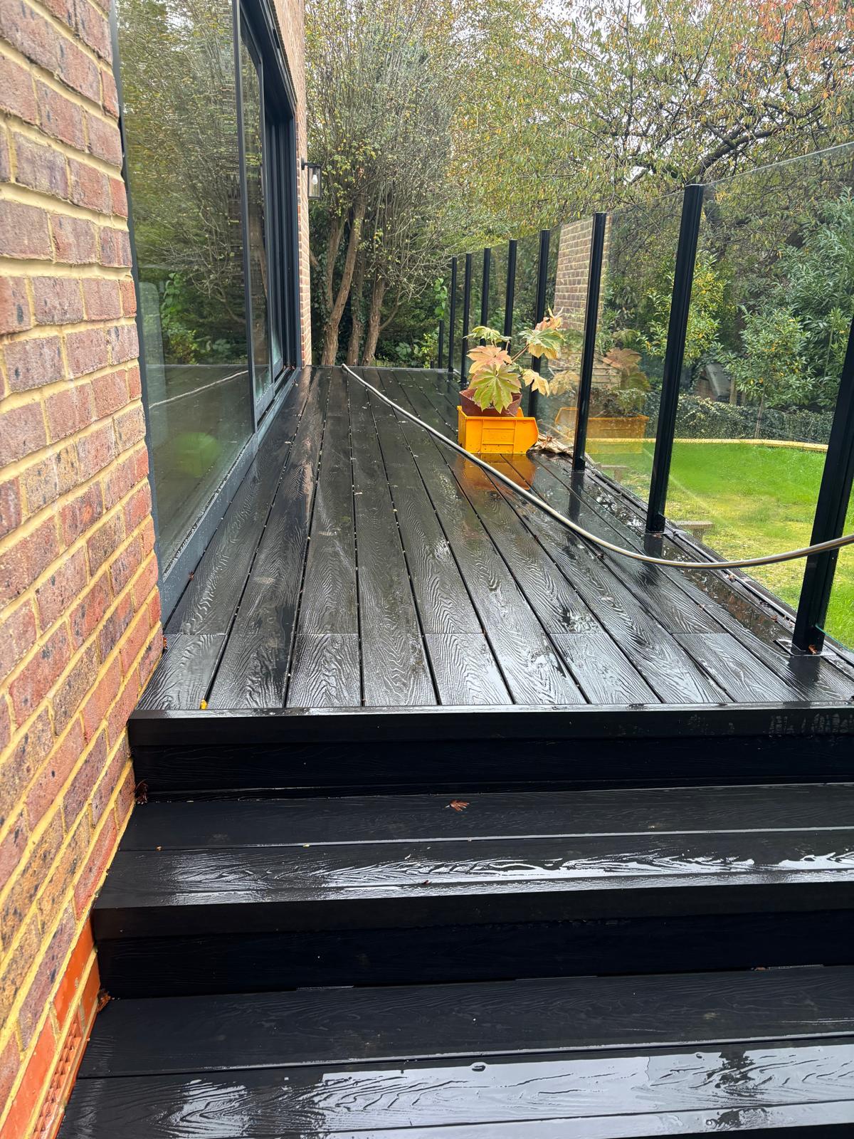 Black composite decking with frameless glass balustrade